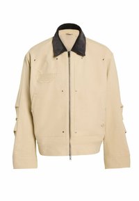 Beżowa kurtka bomberka z czarnym kołnierzem z sztruksu, zamkiem błyskawicznym, bocznymi kieszeniami i haftowanym logo. Tkanina o fakturze z metalowymi srebrnymi ćwiekami.