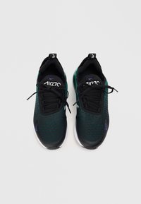 Czarno-zielone buty sportowe z teksturowaną cholewką, okrągłym noskiem, sznurowanym zapięciem, wyściełanym kołnierzem i białą podeszwą. Na języku znajduje się logo.