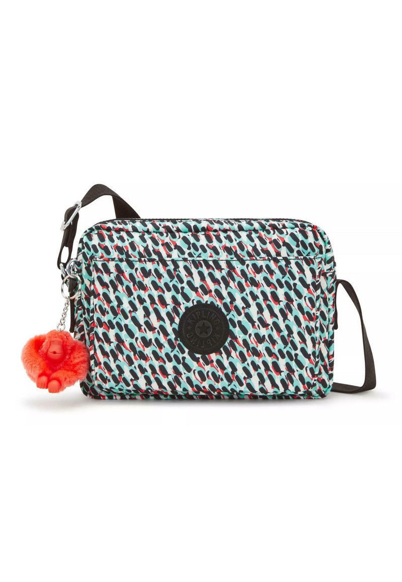 Rechteckige Schultertasche mit einem bunten Muster aus blauen, roten und schwarzen Formen. Verfügt über ein schwarzes Logo und einen roten Affen-Schlüsselanhänger.