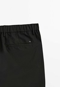Pantalons noirs avec une finition texturée, dotés d'une taille élastique et d'une poche arrière avec un discret logo.