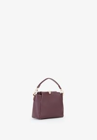 Compact bordeaux handtas van textuurleer. Voorzien van een kort handvat en goudkleurige hardware met een sluiting.