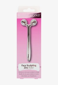 Sinkeface roller med glitrende sølvfinish, med to runde ender, montert på et slankt håndtak. Pakket mot en rosa bakgrunn.