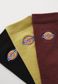 Tre par strumpor i svart, guld och burgundy, med "Dickies" logotyp broderad på varje. Texturerad stickdesign.