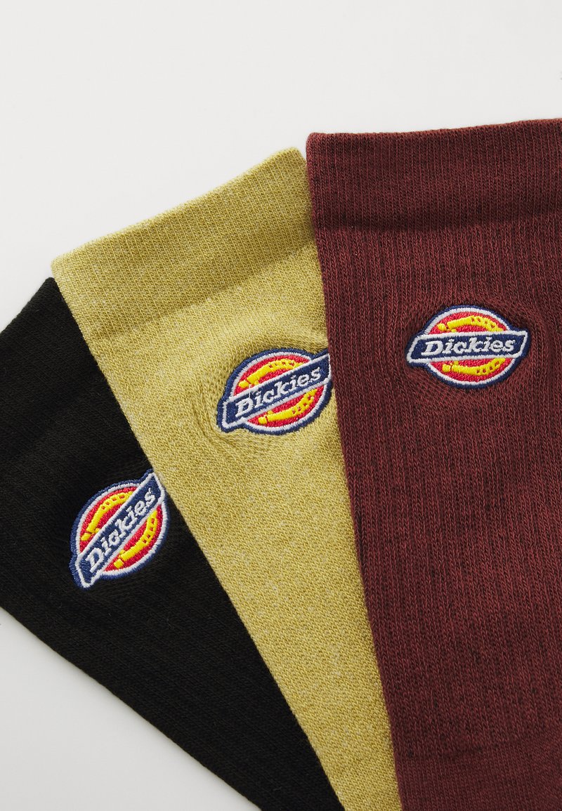 Tre par sokker i sort, guld og bordeaux, med "Dickies" logo broderet på hver. Teksturert strikdesign.