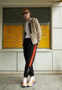 Calvin Klein Jeans STACKED PANT - Spodnji deli trenirk - black/coral orange