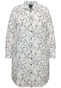 Camicia bianca con bottone, caratterizzata da disegni astratti di volti neri, maniche lunghe e orlo curvo. Presenta un colletto classico e bottoni neri.