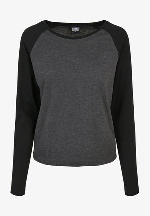Camiseta de manga larga con cuerpo gris y mangas raglán negras, fabricada con un tejido suave de textura lisa y cuello redondo.