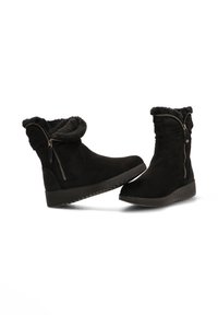 Botas de ante negro hasta la mitad de la pantorrilla con forro de piel sintética, cremallera lateral y suela gruesa y texturizada. Diseño suave y flexible con puntera redondeada.