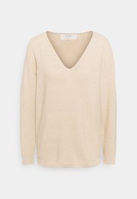 Kremowy, długi sweter z dzianiny z głębokim dekoltem w serek i prążkowanymi mankietami, przedstawiony na białym tle.