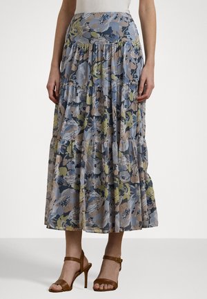 Blomstrete maxi-skjørt med lagdelte volanger, i nyanser av blått, grønt og beige. Laget av lett stoff. Kombinert med brune hælsandaler.