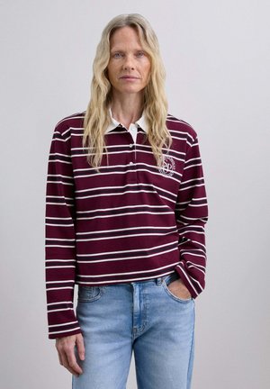 Polo de manga larga a rayas marrón y blanco con cuello y cierre de botones; presenta un detalle de logo en el pecho y un corte relajado.