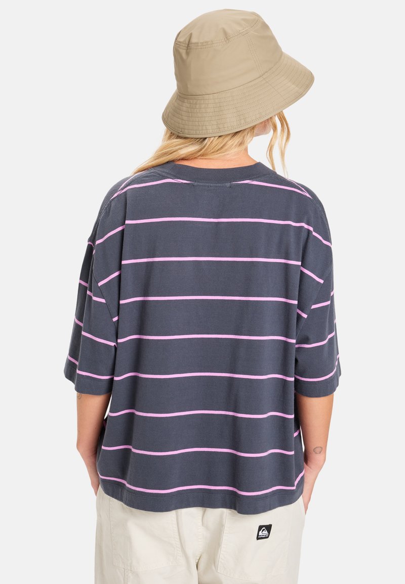 T-shirt gris surdimensionné avec des rayures horizontales roses, col rond et manches courtes. Présente une patch logo au dos.