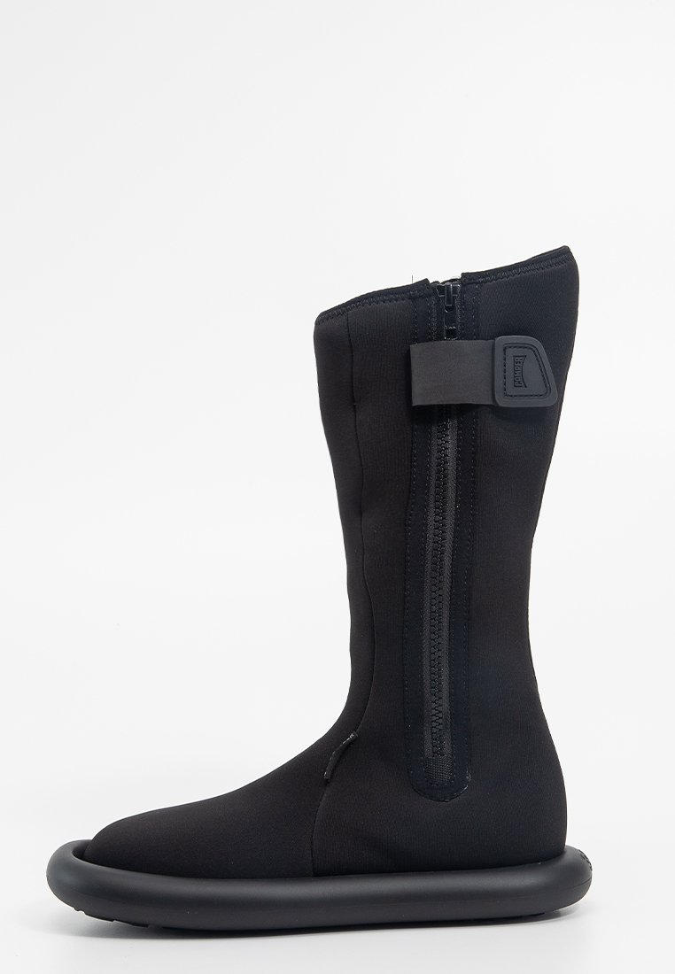 Czarne wodoodporne botki o wysokim, smukłym fasonie. Zawierają boczny zamek błyskawiczny, miękki materiał górny oraz okrągłą gumową podeszwę.