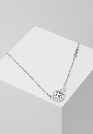 Silberkette mit rundem Anhänger, der ein filigranes, ausgeschnittenes Design zeigt, umgeben von kleinen klaren Steinen.