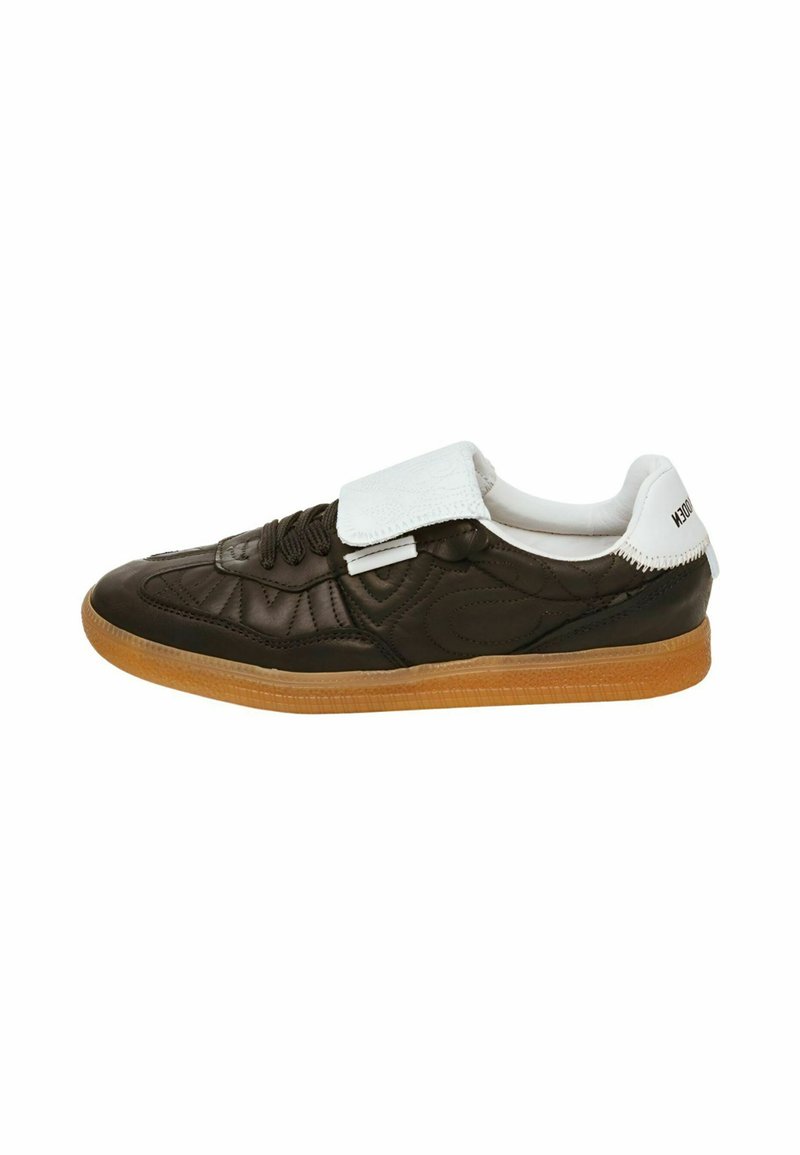 Sneaker in pelle marrone con un design imbottito, fascia adesiva bianca e suola in gomma. Presenta una superficie testurizzata e un branding minimale.