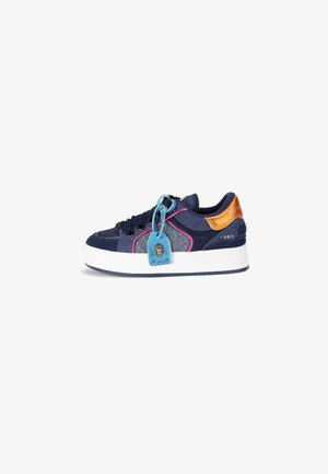 Sneaker blu navy con tessuto testurizzato e accentuazioni in bronzo lucido. Presenta una suola bianca spessa, cuciture colorate e un'etichetta decorativa blu.
