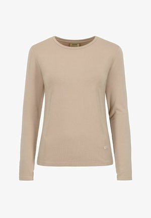 Beżowa koszula z długim rękawem, wykonana z miękkiego materiału, posiadająca okrągły dekolt i mały akcent logo na dolnej części przodu. Prosty design.