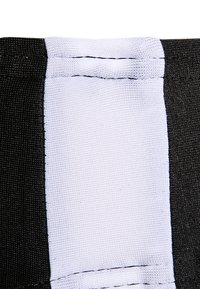Czarna tkanina o fakturowanym wykończeniu z białym paskiem. Szycie widoczne na brzegach. Prosty design w prostokątnym kształcie.