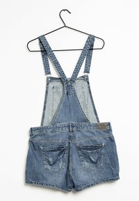 Jeansoverall med justerbara remmar, blåtvätt, med en bib fram och korta byxor, med två bakfickor och en texturerad yta.