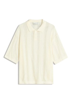 Polo a maniche corte con un motivo a maglia aperta e testurizzato color crema chiaro. Presenta un colletto e una patta con tre bottoni.