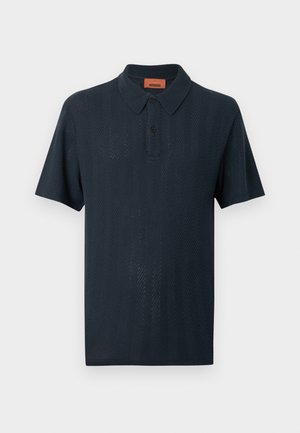 Polo a maniche corte blu navy con motivo a chevron sottile a maglia e abbottonatura a due bottoni, mostrata su sfondo bianco semplice.