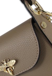 Beige leren handtas met een gestructureerde afwerking, voorzien van een gouden bijdecoratie en een zwarte randafwerking. Inclusief een gouden sluiting.