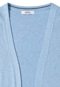 Lichtblauwe gebreide cardigan met open voorzijde en een wit label met de tekst "CECIL" op de hals.