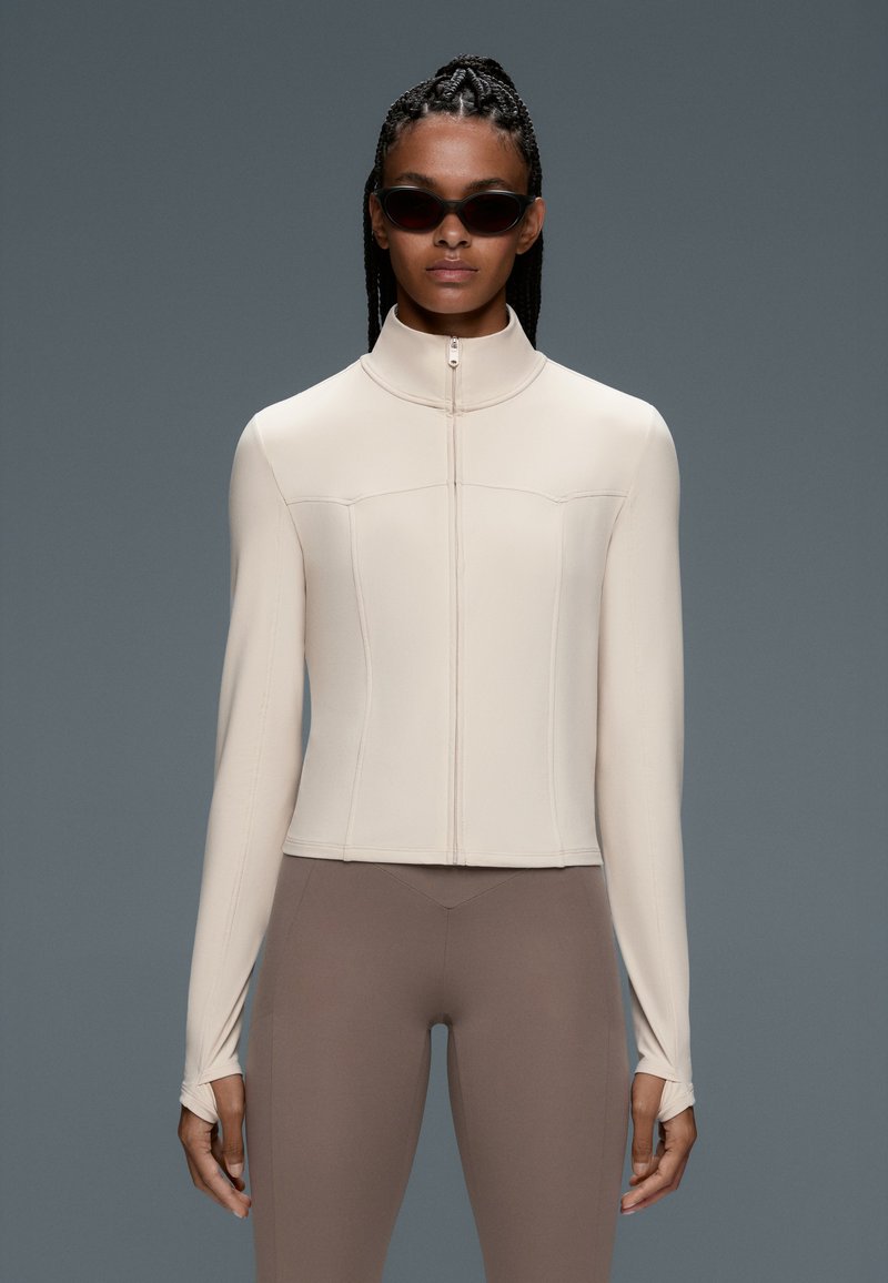 Variation Exercise Background OYSHO LIGHT WARM SHORT TECHNICAL JACKET - Training jacket - ecru/beige ...