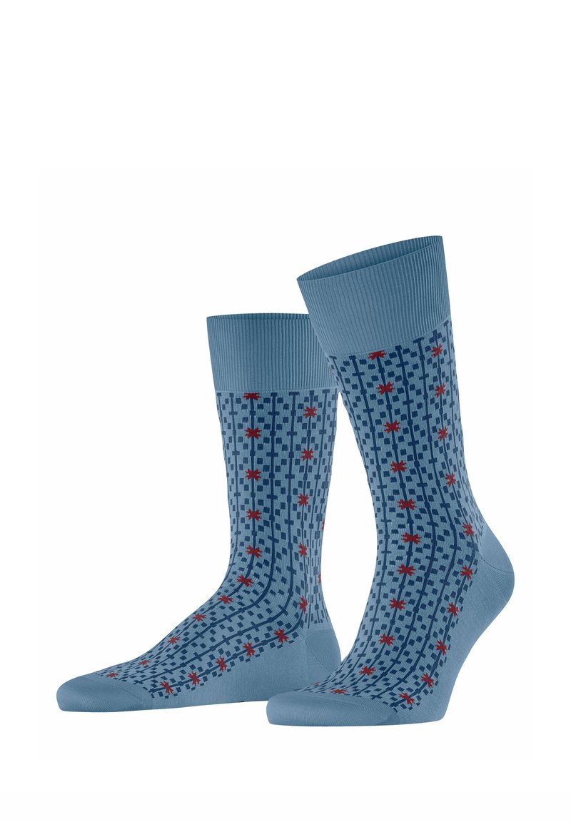 Paar blaue Knöchelsocken mit marineblauem Karomuster und kleinen rotsternähnlichen Formen, die über den gesamten Stoff verteilt sind.