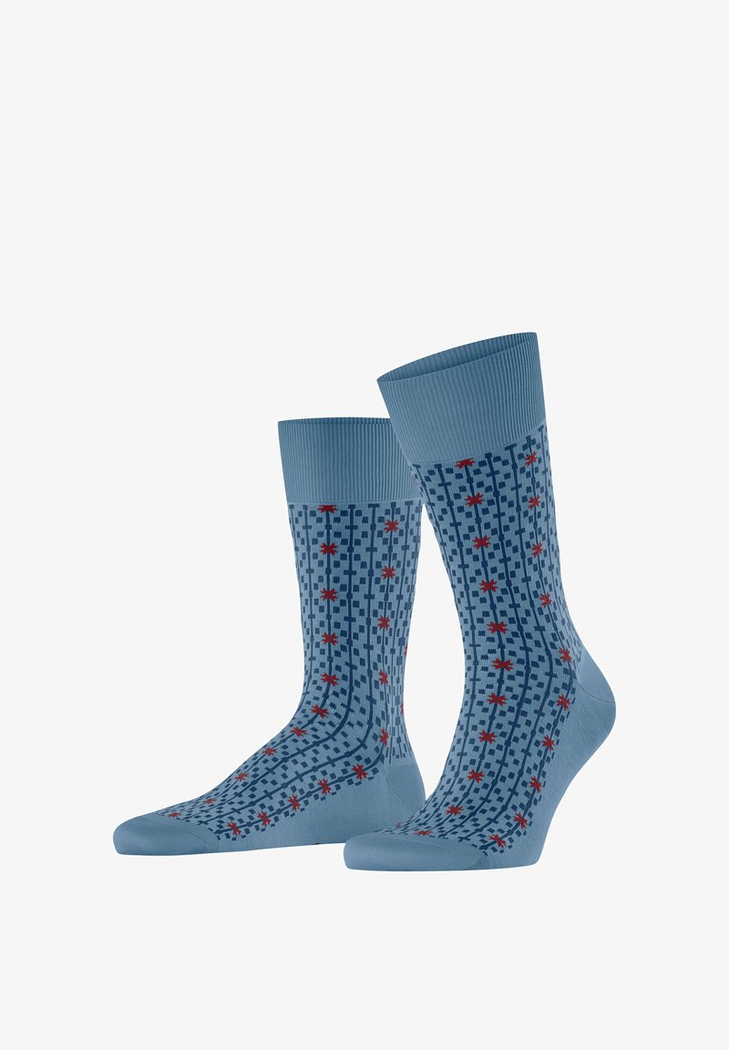 Paar blaue Knöchelsocken mit marineblauem Karomuster und kleinen rotsternähnlichen Formen, die über den gesamten Stoff verteilt sind.