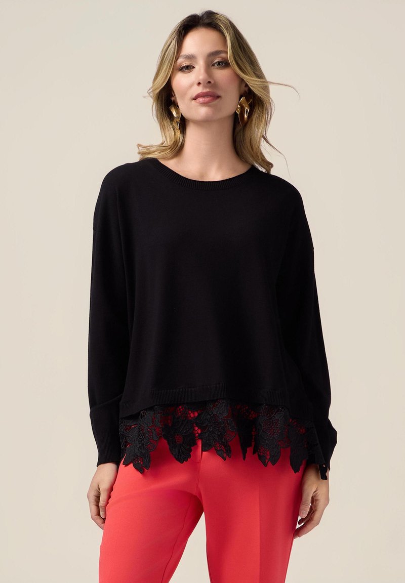 Maglione nero a maglia con scollo rotondo e maniche lunghe, caratterizzato da un orlo con rifinitura in pizzo ondulato e intricati motivi floreali in tonalità scure.
