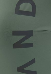 Grüßer dehnbarer Stoff mit großen schwarzen Buchstaben "M" und "Z", der eine glatte Textur und eine enganliegende Passform aufweist.