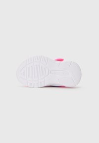 Semelle de chaussure en caoutchouc blanc avec un motif de grip texturé, présentant un accent rose près du talon et de profondes rainures le long de la base pour une meilleure adhérence.