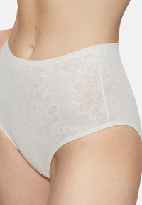 Białe koronowe majtki z wysokim stanem, zdobione kwiatowymi wzorami po bokach, o miękkiej teksturze i bezszwowych krawędziach dla wygody.