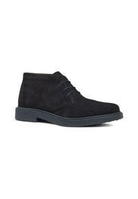 Stivaletti minimalisti in camoscio nero con punta tondeggiante e chiusura con lacci. Presentano una suola in gomma nera a contrasto.