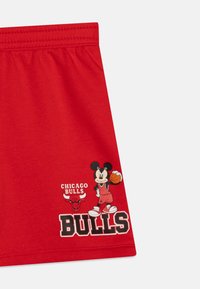 Červené basketbalové šortky s elastickým pásom. Obsahujú grafiku Mickeyho Mousea v uniforme Bulls a text "Chicago Bulls".