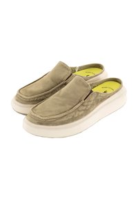 Zapatos beige tipo slip-on con parte superior de lona suave y cuello acolchado. Suela de goma blanca con un diseño texturizado. Plantilla de color amarillo brillante visible.