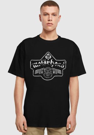 Black cotton t-shirt featuring a metallic silver graphic of the Motörhead logo with a skull and wings design at the center.