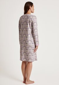 Langärmliges Nachthemd in hellem Lila mit Paisley-Muster. Es zeichnet sich durch einen weichen Stoff, einen runden Ausschnitt und Bündchen in einer passenden Farbe aus.