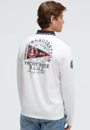 Long-sleeve white polo shirt with navy collar and detailed nautical graphic on back, featuring an anchor and flag design with text accents.