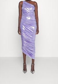 Jednobarevné, přiléhavé šaty na jedno rameno z lesklé lila látky, s drapériemi a asymetrickým lemem. Stříbrné špičaté podpatky dotvářejí vzhled.