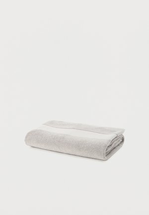 Light gray folded cotton towel with a white stripe along the edge on a plain white background.