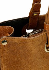 Brązowa torebka z zamszu z skórzanymi akcentami, z zamkiem błyskawicznym, wykończona złotymi detalami; zaokrąglony kształt i teksturowana powierzchnia.