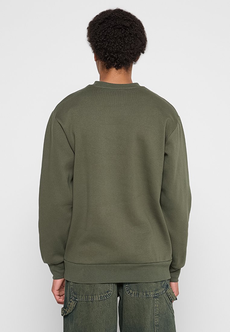 Olijfgroene sweatshirt met een geribbelde ronde hals, lange mouwen en een strakke zoom. Gemaakt van zachte, gestructureerde stof. Eenvoudig, onopgesmukt ontwerp.