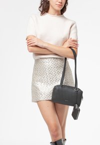Borsa a tracolla in pelle nera con superficie testurizzata, forma rettangolare e lunghe cinghie. Include una piccola pochette con cerniera abbinata attaccata.