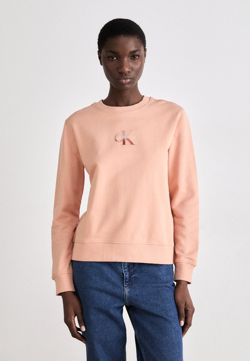 Sudadera rosa de algodón, con cuello redondo y manga larga. Cuenta con un pequeño detalle de logo en el pecho y un dobladillo recto.