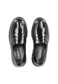 Schwarze, glänzende Slipper mit glatter Textur, ausgestattet mit einem gesteppten Riemen und einer klobigen Sohle. Markenlogo auf den Einlegesohlen sichtbar.