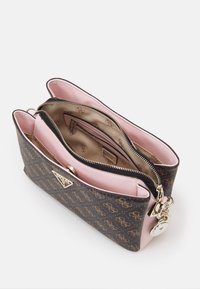 Malá hnědo-růžová kabelka Guess s monogramem, zlatým zipem, předním zapínáním na knoflík a vnitřní kapsou na zip.