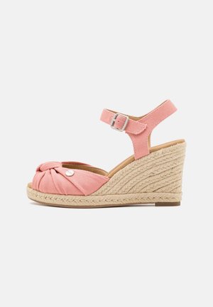 Pink kileformet sandal i stof med åben tå, fletdet sål i jute, ankelrem og sølvspænde på hvid baggrund.