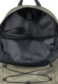 Zaino in tela verde con interno in nylon nero, dotato di tasca in rete, spallacci regolabili e cordino bungee per ulteriore spazio di stoccaggio.
